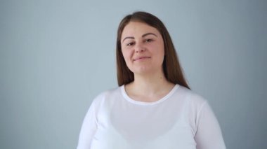 Güzel, büyük beden bir kız model, gülümseyerek kameraya gülümsüyor. 30 'lu yaşların başındaki çekici genç bir kadının, neşeli bir yüz ifadesiyle stüdyoda poz verirken çekilmiş portresi.