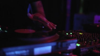 Konser DJ 'i turntable ve vinil plaklarla müzik çalıyor. Profesyonel kulüp jokeyi neon ışıklarıyla sahnede müzik parçaları çalıyor. DJ gece kulübünde parti ayarlıyor ve video klipte çekiliyor.