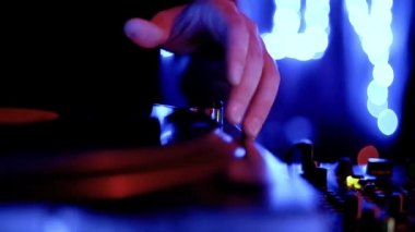 Techno dj, gece kulübünde, analog turntable çalarken retro vinil plaklar eşliğinde müzik setini çalıyor. Müzik parçalarını neon ışıklarda karıştıran profesyonel disk jokeyinin video klibi 