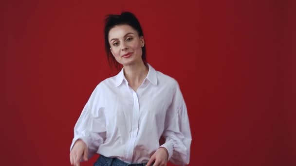 Jovem Feliz Dançando Estúdio Fundo Vermelho Vestindo Camisa Branca Casual — Vídeo de Stock