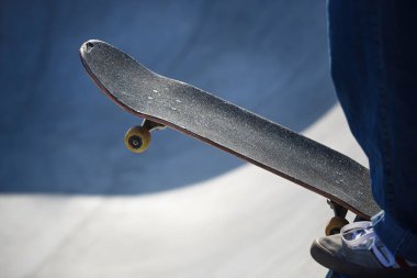 Kaykaycı adam beton havuzda kaykaya biniyor.