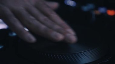 Gece kulübünde DJ müzik ve Midi kumanda cihazını karıştırıyor. Profesyonel disk jokeyi video klipte elektronik müzik parçalarını karıştırıyor