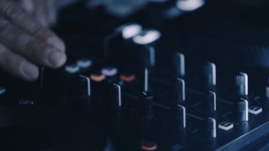Disk jokeyi, gece kulübünde müzik parçalarıyla pikap aletini karıştırıyor. Profesyonel DJ gece kulübünde Midi kontrolörüyle elektronik müzik çalar.