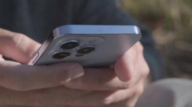 KYIV - 20 Ekim 2021: Iphone 13 Pro akıllı telefonunda daktilo. Adam yeni 2021 Apple iPhone cihazına Sierra Blue renginde bir mesaj yazar