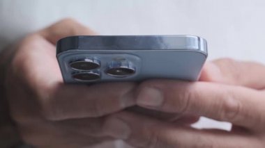 KYIV - 20 Ekim 2021: Yeni Iphone 13 Pro akıllı telefon kullanımda. Genç adam 4K video klipinde Sierra Blue renginde yeni Apple cep telefonu kullanıyor