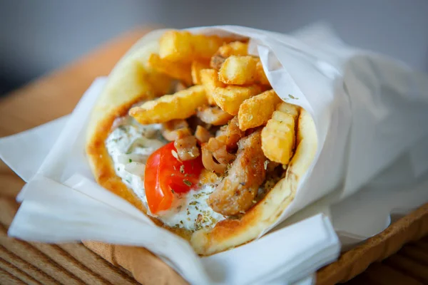 苏夫拉基三明治 佐治沙司 油炸厨房肉 茴香薯条和新鲜蔬菜包在比萨面包里 传统希腊快餐菜 — 图库照片