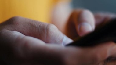 Cep telefonunda yazı yazan eller. Adam akıllı telefondaki kurye uygulamasına mesaj yazar, 4K videosunda görüntülenir.