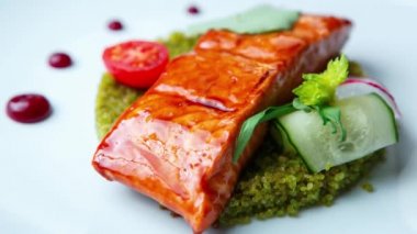 Izgarada pişirilmiş somon balığı filetosu ve deniz ürünleri restoranında kuskus ve sebzelerle servis edilen stok yiyecek videosu..