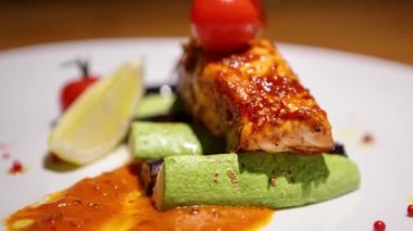 Izgarada pişirilmiş somon balığı filetosu stok gıda videosu ve deniz ürünleri restoranında akşam yemeği için sebzelerle servis.