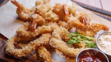 Akşam yemeği için deniz ürünleri restoranında kızartılmış karides pişirip kağıt tabakta servis ediyorlar.