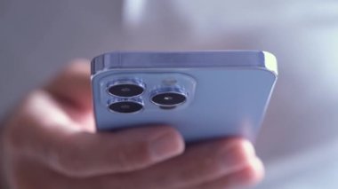 KYIV - 8 Ekim 2021: Sierra Blue renkli Iphone 13 Pro yakın çekim video klibinde gerçek hayatta kullanıldı. Modern Apple cep telefonu kullanan adam 