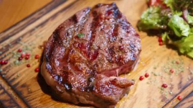 Izgarada pişirilmiş bonfile biftekli çorap yemeği videosu ve Amerikan bbq restoranında akşam yemeği için ahşap tabakta servis.