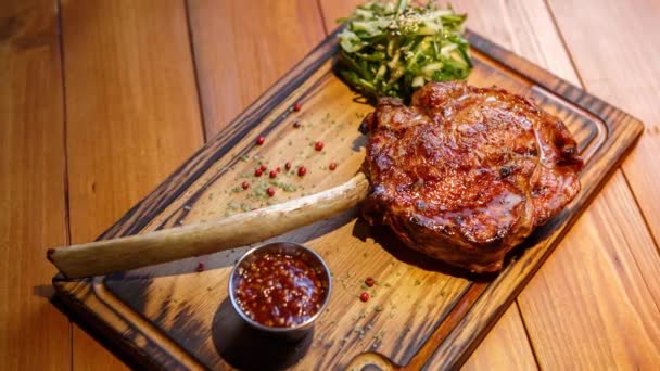Tomahawk Steak Csonton Tálalva Rusztikus Fából Készült Tányéron Áfonyaszósszal Húsétteremben — Stock videók