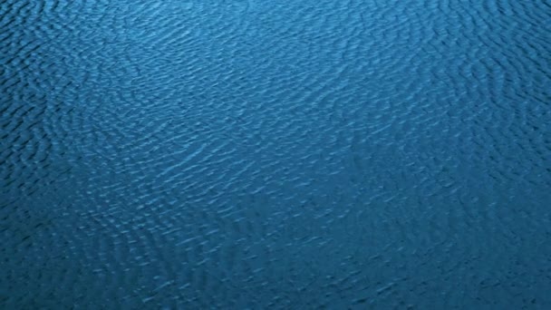 スローモーションで撮影された水の波紋の空中ドローンビデオ 上から空飛ぶビデオカメラで撮影された青い海の表面 — ストック動画