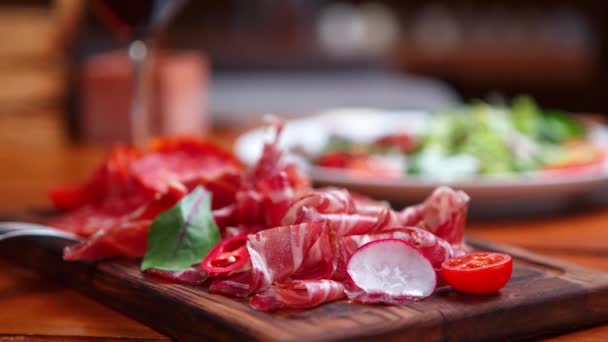 切好的意大利火腿和西班牙火腿放在木板上 在肉店里当点心吃 — 图库视频影像