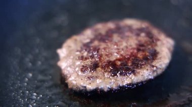 Yakın çekim videoda ızgarada kıymalı köfte kızartması. Akşam yemeği için hamburgerin pişirildiği makro görüntüler.