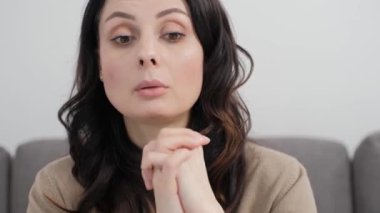 Çevrimiçi öğretmenlik. Öğretmen video için arıyor. 30 'lu yaşlardaki esmer kadın portresi kameraya bakıyor ve jestlerle konuşuyor. 4k ultra HD 'de Royalty ücretsiz stok videosu