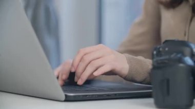 Serbest fotoğrafçı evden tecrit altında çalışıyor. Dizüstü bilgisayar üzerinde çalışan profesyonel resim rötuşçusunun stok video klibi.