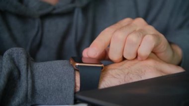 Akıllı saatler kullanan serbest çalışan biri. Kol saati cihazında internete bağlanan kişi bildirileri. Çevrimiçi iletişim için modern ukalaları kullanıyor. Adam 4K stok videoda kol saati kullanıyor.