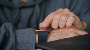 Akıllı saatler kullanan serbest çalışan biri. Kol saati cihazında internete bağlanan kişi bildirileri. Çevrimiçi iletişim için modern ukalaları kullanıyor. Adam 4K stok videoda kol saati kullanıyor.
