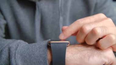 Akıllı saatlerde mesaj okuyan bir adam. Çevrimiçi iletişim ve iletişim için modern kol saatini kullanan kişinin stok videosu. 4K görüntüde smartwatch aygıtı hakkında erkek parmak basma uyarısı