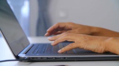 Laptop klavyesinde yazan serbest çalışan bir kadın. Kilitleme sırasında evde dizüstü bilgisayarda çalışan genç siyahi bir kadın. Profosyonel uzaktan çalışma, 4k ultra HD ile çekilen konsept.