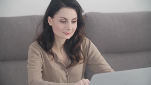 コンピュータを入力するプロのビジネス女性 ロックダウン中に自宅のノートパソコンで働く若い女性に焦点を当てました フリーランスは4Kストックビデオでリビングルームでノートブックで遠くの仕事をして — ストック動画