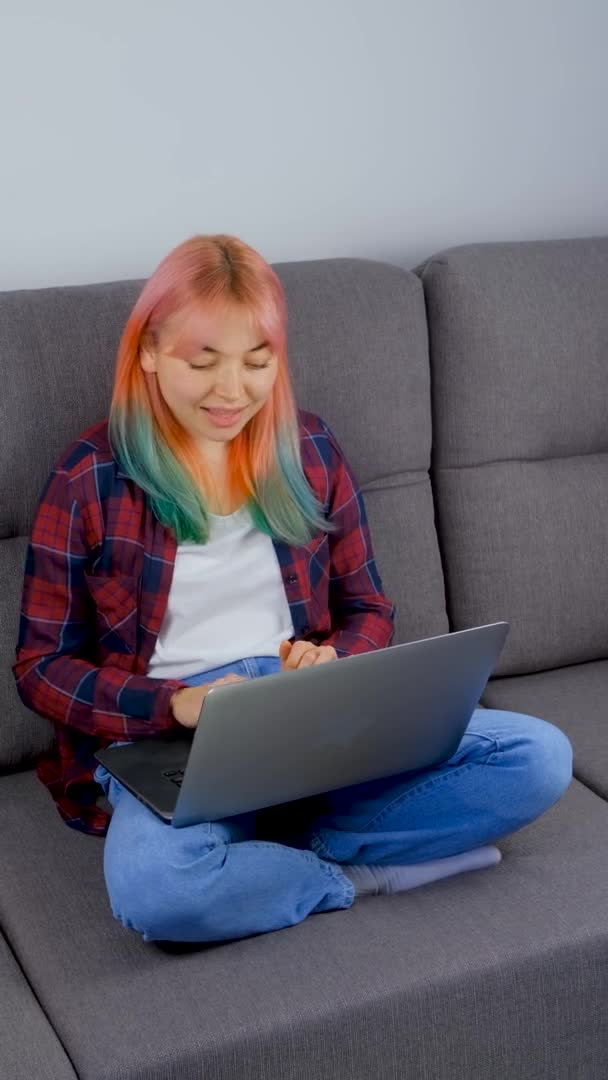 有一头彩色头发的自由职业者女孩在家里干活 免费长矛女作家 坐在公寓里锁起来的时候 在笔记本电脑上用染发液打字 4K中自由落体的库存视频 — 图库视频影像