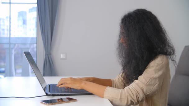 フリーランスのライターの女性は ノートパソコンのキーボードにテキストを入力します ロックダウン中に自宅からオンラインで働くプロの無料ランサー女性 黒人女性は遠くの仕事をし 現代的なインターネット技術を使用して — ストック動画