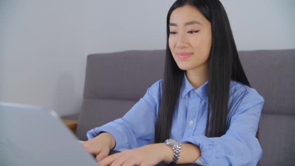漂亮的年轻亚洲女人在4K股票视频的笔记本电脑上工作 可爱的20多岁的越南女孩在家里的笔记本电脑上做远程自由职业工作 免费拍摄的影片 — 图库视频影像
