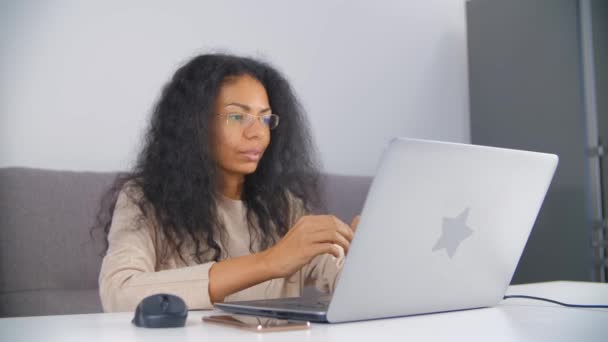 视频呼叫和在线教学的概念 黑人妇女在网络摄像头上友好地微笑着说话 快乐的非洲女性通过网络连接与学生交谈 在家里工作的自由职业者 — 图库视频影像