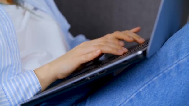 フリーランスの女性がノートパソコンのキーボードにテキストを入力します ソファに横たわっている間 創造的な専門家はロックダウンで自宅から遠くの仕事をしています 4Kストックビデオクリップのフリーランス作業 — ストック動画