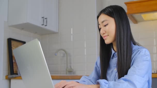 在笔记本电脑上工作的年轻美丽的亚洲女人 远程学习的概念拍摄于4K 可爱的越南女孩在家里的笔记本电脑上打字 关在家里做自由职业的妇女 — 图库视频影像