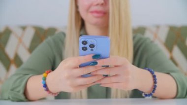 Beyaz kadın cep telefonundan mesaj yazıyor. Genç beyaz kadın, kameralı akıllı telefon kullanıyor. Yakın plan stok videosunda modern cep telefonuyla iletişim kuran kişi