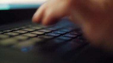 4K 'lık yakın çekim videosunda eller yazılıyor. Geceleri dizüstü bilgisayarda çalışan biri. Bilgisayarla uzaktan çalışan bir adamın Macro stok görüntüleri.