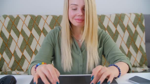 在笔记本电脑上工作的漂亮的金发白人女人 年轻的白人女性在家里的笔记本电脑上打字 在4K视频中做远程在线工作的自由职业者 — 图库视频影像
