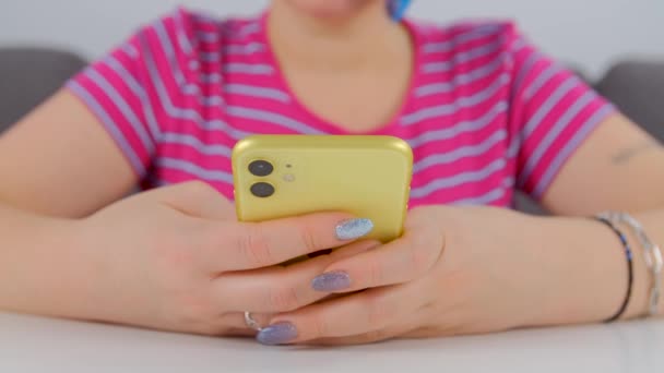 Žena píšící SMS na mobilním telefonu. Žena používající moderní žluté smartphone zařízení pro komunikaci online. Osoba držící nový mobil gadget v detailní stock videa fimed v 4k ultra hd