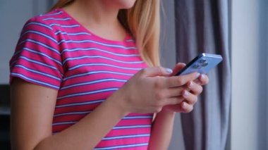 Stok videosunda modern cep telefonu kullanan bir kadın. Sosyal medya uygulamasında akıllı telefondan mesaj yazan genç kız