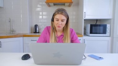 Çevrimiçi destek uzmanı mikrofonlu kulaklık takarak web kamerasından konuşuyor. Tecrit sırasında evden internet üzerinden çalışan profesyonel bir yardımcı. Neşeli satış müdürü müşteriyle konuşuyor.
