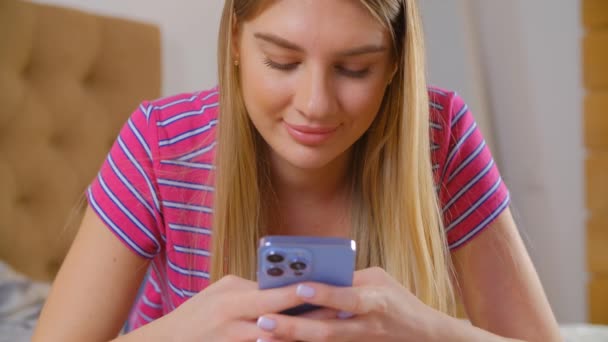トリプルカメラで現代の携帯電話上のメッセンジャーアプリにメッセージを入力する美しい白い女性 かなり若い大人の女性は スマートフォンでオンライン通信 携帯電話での陽気な人のメッセージ — ストック動画