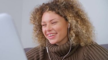 Duygusal video çağrısı. Web kamerasında konuşan mutlu beyaz kadın. Kulaklık takmış güzel beyaz kadın dizüstü bilgisayarda neşeli bir ifadeyle yakın çekim stok görüntüleriyle konuşuyor.