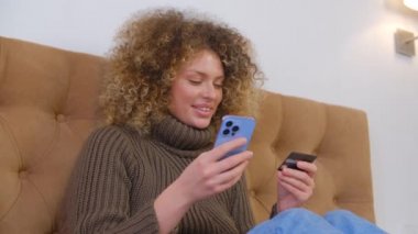 Kredi kartı ve cep telefonuyla online alışveriş. Mutlu beyaz kadın, modern akıllı telefondan neşeli bir gülümsemeyle ödeme yapıyor. Müşteri cep telefonuyla alışveriş uygulamasında banka kartıyla ödeme yapıyor.