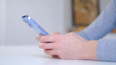 Cep telefonu kullanan bir kadın. Modern mavi akıllı telefon cihazında sosyal medya uygulamasında kadın yazıcı mesajı. Yeni cep telefonu aygıtı ve hızlı internet bağlantısı ile çevrimiçi iletişim kuran kişi