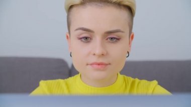 Erkek Fatma bilgisayar kullanıyor. Kısa saçlı güzel bir kadın tecrit sırasında dizüstü bilgisayarla çalışıyor. İnternet bağlantısı ve dizüstü bilgisayarı olan çekici bir genç.
