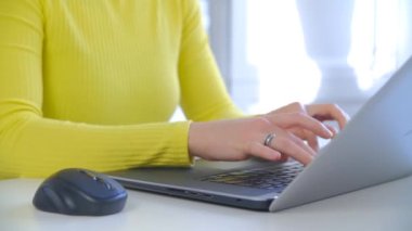 Evde defter bilgisayarı üzerinde çalışan serbest çalışan kadın. Evde dizüstü bilgisayarda yazan genç bir kadın. Tecrit sırasında internetten uzak işler yapan profesyonel serbest yazar.