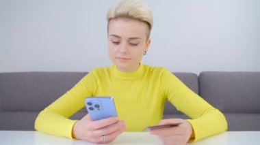 İnternetten kredi kartıyla ödeme. Cep telefonu uygulaması ve banka kartıyla internet mağazası satın alan bir kadın. Modern akıllı telefonla internet üzerinden müşteri alımı