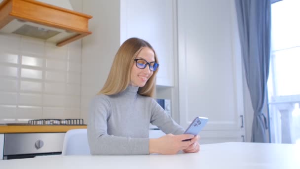 Mujer Joven Con Gafas Escribir Mensaje Teléfono Inteligente Mesa Casa — Vídeo de stock