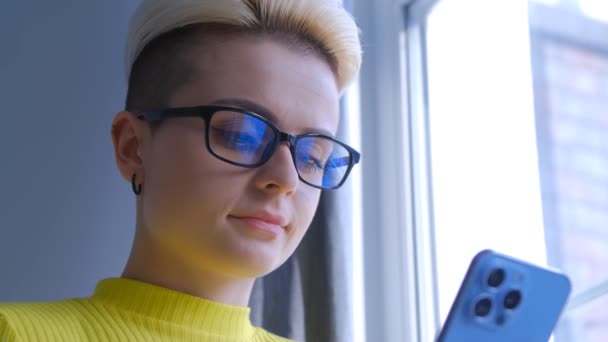年轻的白人妇女在电话上输入消息 用现代智能手机进行在线交流的有短发的时髦女性 戴眼镜的汤姆男孩在社交媒体应用程序上写评论 — 图库视频影像