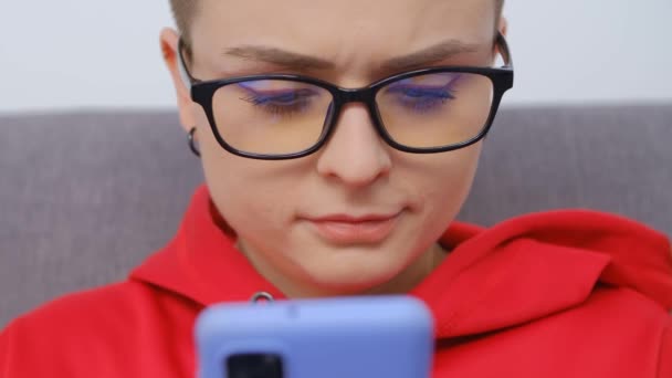 漂亮的白发女 汤姆男孩戴眼镜 用4K的库存视频使用现代手机 迷人的年轻人在智能手机上浏览互联网和社交媒体应用程序 — 图库视频影像