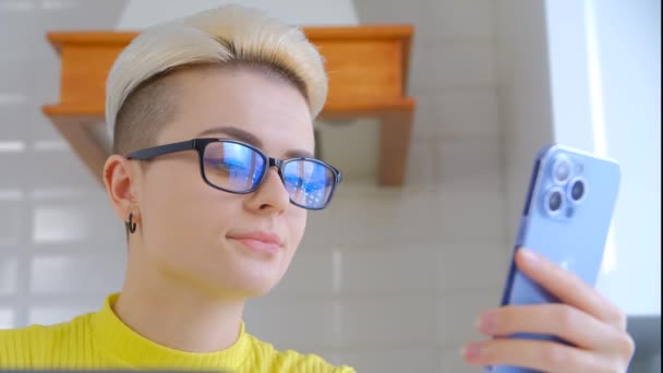 Νεαρή Γυναίκα Που Χρησιμοποιεί Και Παρακολουθεί Στο Smartphone Στο Δωμάτιο — Αρχείο Βίντεο